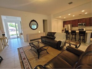 Relax in this stylish living space with a comfortable sofa, glass coffee table, and large mirror.
