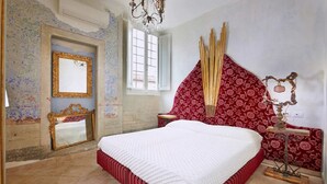 Una camera da letto con un letto grande, uno specchio e una finestra.
