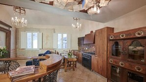 Una cucina con mobili in legno, un fornello e un lampadario.