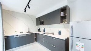 A modern kitchen with grey cabinets, a white countertop, and a built-in microwave. - Sunset 202 Luxury With gym Club in Lac 1 (Tunis)
