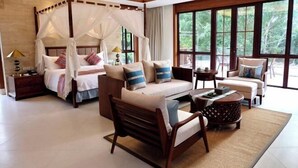 A spacious bedroom with a canopy bed, a sofa, a coffee table, and a view of the outdoors through large windows. - Qixianling Zhongnan Hot Spring Apartment Hotel (Baoting)