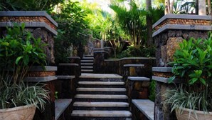 A stone staircase surrounded by lush greenery, leading to a higher level. - Qixianling Zhongnan Hot Spring Apartment Hotel (Baoting)