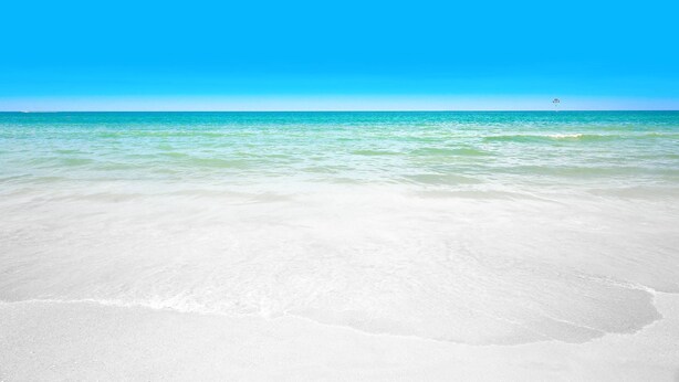 Una spiaggia con acque cristalline turchesi e sabbia bianca.