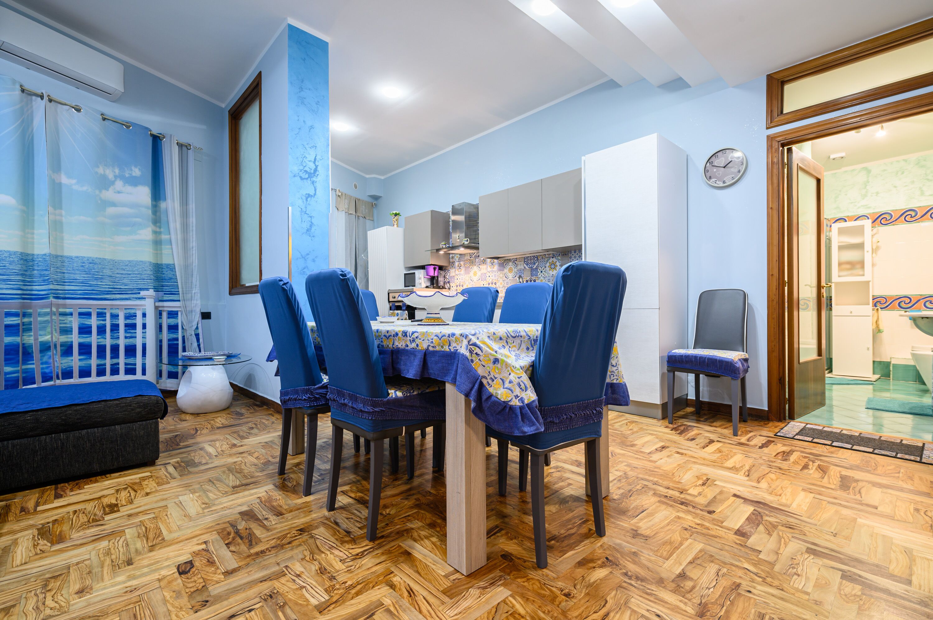 A dining area with a table set for four, surrounded by blue chairs.