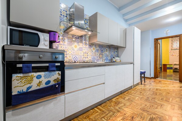 A kitchen with a microwave, oven, and modern cabinetry.