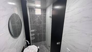 Een douche, handdoeken, zeep, toiletpapier