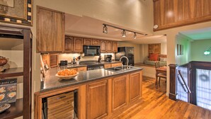 A modern kitchen with wooden cabinets, a central island, and built-in appliances. - Updated Apartment in Historic Dtwn Marshall! (Marshall)
