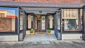A building entrance with a brick facade, a metal gate, and a small staircase leading to the entrance. - Updated Apartment in Historic Dtwn Marshall! (Marshall)