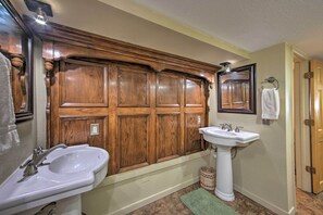 Un baño con tocador de madera, lavabo blanco y espejo.