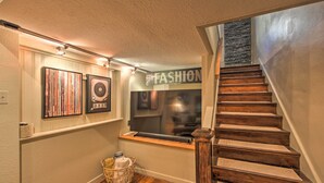 A staircase with wooden steps and a handrail, leading to a landing with a window and a wall-mounted sign that reads "The FASHION". - Updated Apartment in Historic Dtwn Marshall! (Marshall)