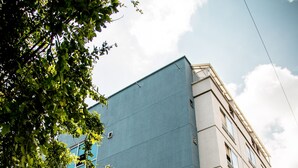Un edificio moderno con fachada azul y el nombre "BELA NOVA" en la planta baja.