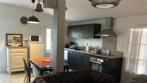 Un espace de vie compact comprenant un coin repas, une kitchenette et un coin salon.