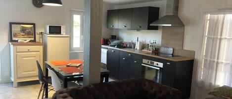 A compact living space with a dining area, kitchenette, and seating area.