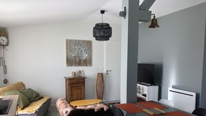 Un salon moderne avec un canapé, une table à manger et un téléviseur.