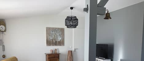 Una sala de estar moderna con un sofá, una mesa de comedor y un televisor.