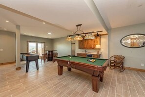 A pool table in a room with a view, wooden cabinets, and a hanging light fixture. - Lazy Creek - Deep Creek Lake - Indoor Lazy River , Boat Dock rental available May-Sept. 2026 (Deep Creek)