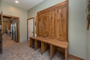 A hallway with a wooden bench, a door, and a refrigerator. - Lazy Creek - Deep Creek Lake - Indoor Lazy River , Boat Dock rental available May-Sept. 2026 (Deep Creek)