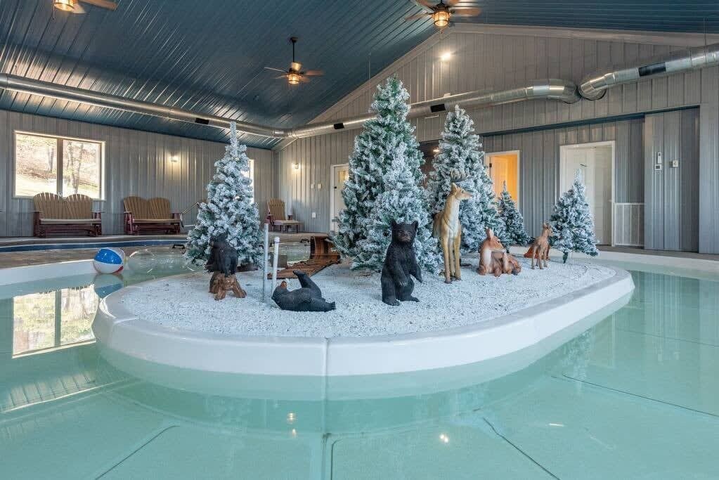 Ein Hallenbad mit winterlicher Dekoration, darunter schneebedeckte Bäume und Tierfiguren.