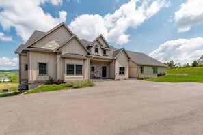 A two-story house with a large driveway and a covered front porch. - Lazy Creek - Deep Creek Lake - Indoor Lazy River , Boat Dock rental available May-Sept. 2026 (Deep Creek)