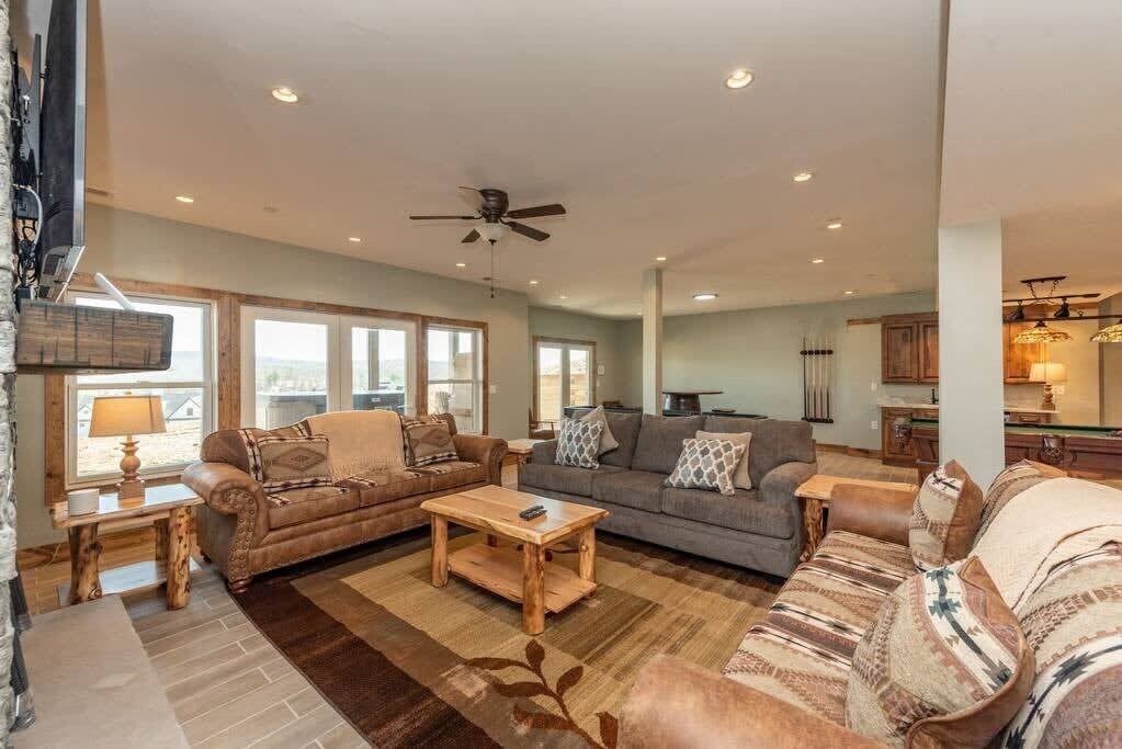 A spacious living room with two sofas, a coffee table, and a ceiling fan.
