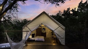 A cozy tented accommodation with a hammock, a bed, and a small bathroom. - Cherry Cove Glamping W/ Hot tub AND Cowboy Pool! (Fredericksburg)