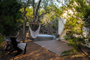 A hammock, a hot tub, and a tent in a wooded area. - Cherry Cove Glamping W/ Hot tub AND Cowboy Pool! (Fredericksburg)