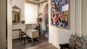 Een kamer met een bureau, stoel en een groot abstract schilderij aan de muur.