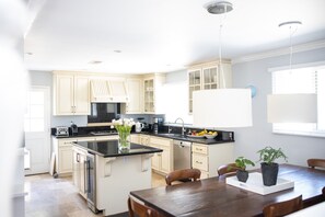 Enjoy cooking in this well-equipped kitchen with a central island, appliances, and a dining area.
