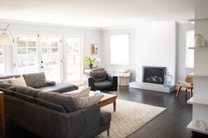 Relax in this inviting living room with a large sofa, armchair, and fireplace.