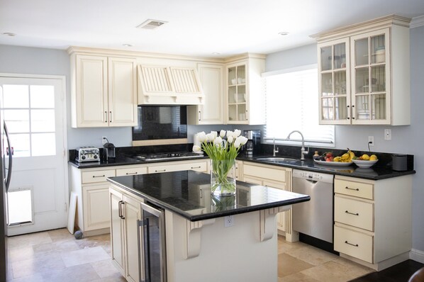 Enjoy cooking in this well-equipped kitchen with a central island, dishwasher, and stainless steel sink.