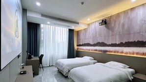 A hotel room with two beds, a desk, a chair, a projector screen, and a large wall mural. - Fenghua Lizhi Hotel (Siyang)