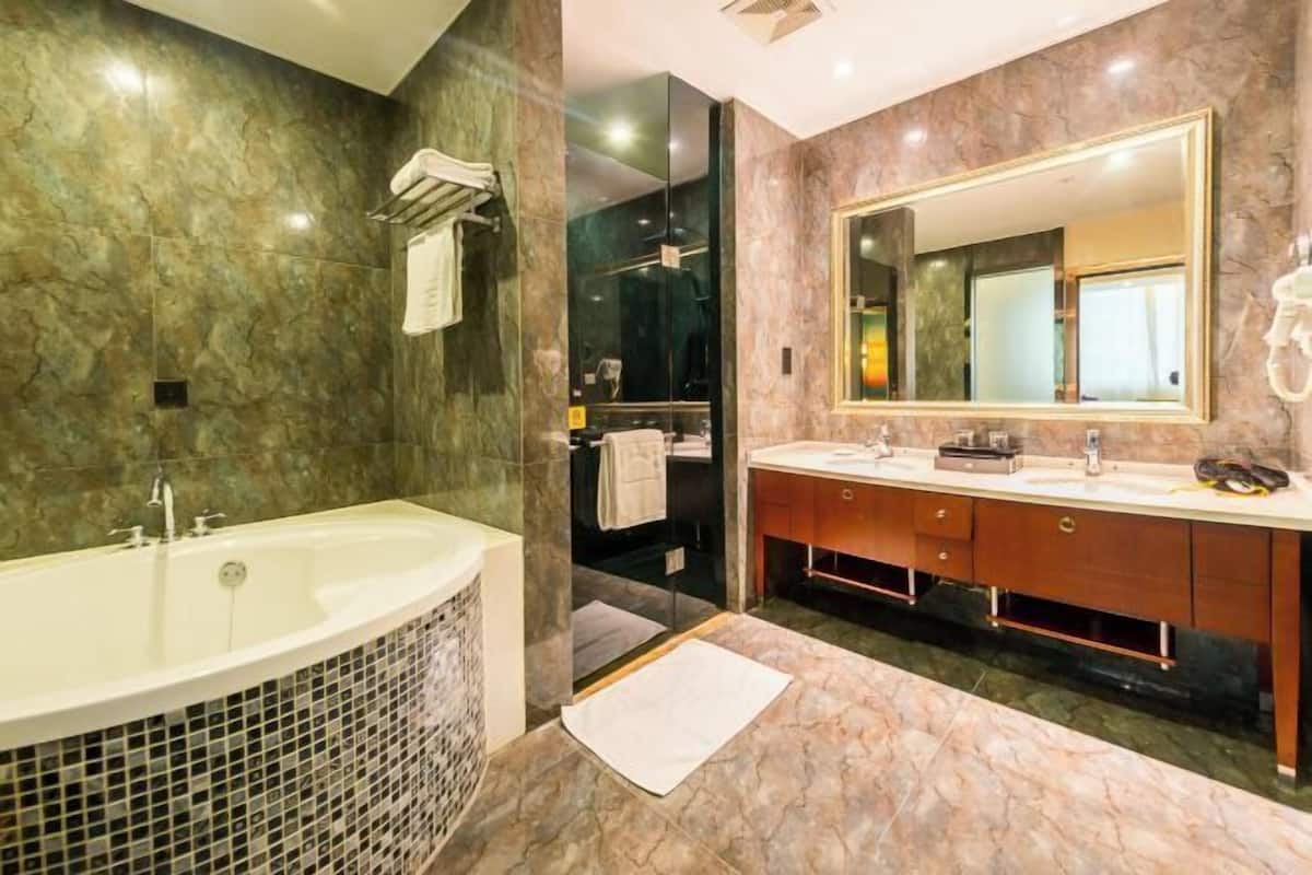 Un baño moderno con una bañera grande, un lavamanos doble con espejo y una zona de ducha.