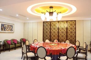A conference room with a round table, chairs, and a decorative wall panel. - Fenghua Lizhi Hotel (Siyang)