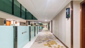 A hotel corridor with glass partitions, a carpet with a floral pattern, and a sign indicating room 8309. - Fenghua Lizhi Hotel (Siyang)