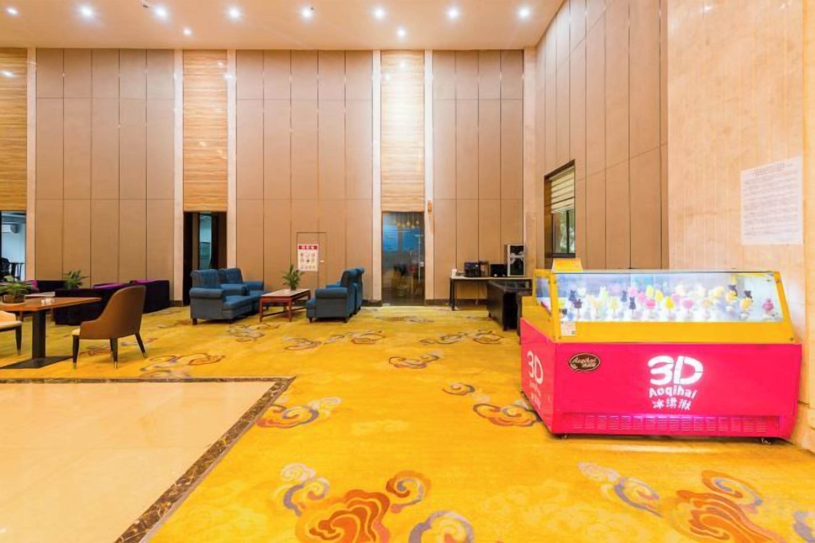 A lobby with a 3D printer, sofas, a reception desk, and a patterned carpet.