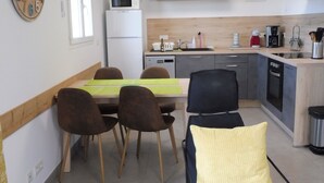 A compact living space with a dining area, a kitchenette, and a seating area with a sofa and chairs. - Apartment in residence with swimming pool, janitor, 7 minutes walk from the beach (Zonza)