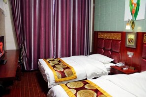 A hotel room with two beds, a red headboard, a television, and a curtain.