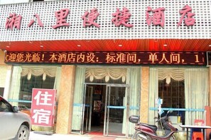 Un hotel con un cartel que indica 'Hotel' y un anuncio de 'Alquiler de habitaciones'.
