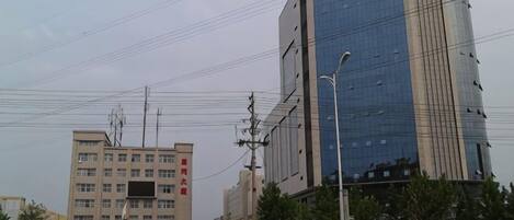 A cityscape with modern buildings, a street with vehicles, and a clear sky.