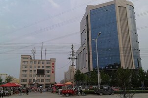 Un paisaje urbano con edificios modernos, una calle con vehículos y un cielo despejado.