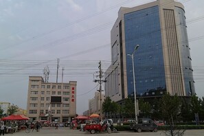 A cityscape with modern buildings, a street with vehicles, and a clear sky.