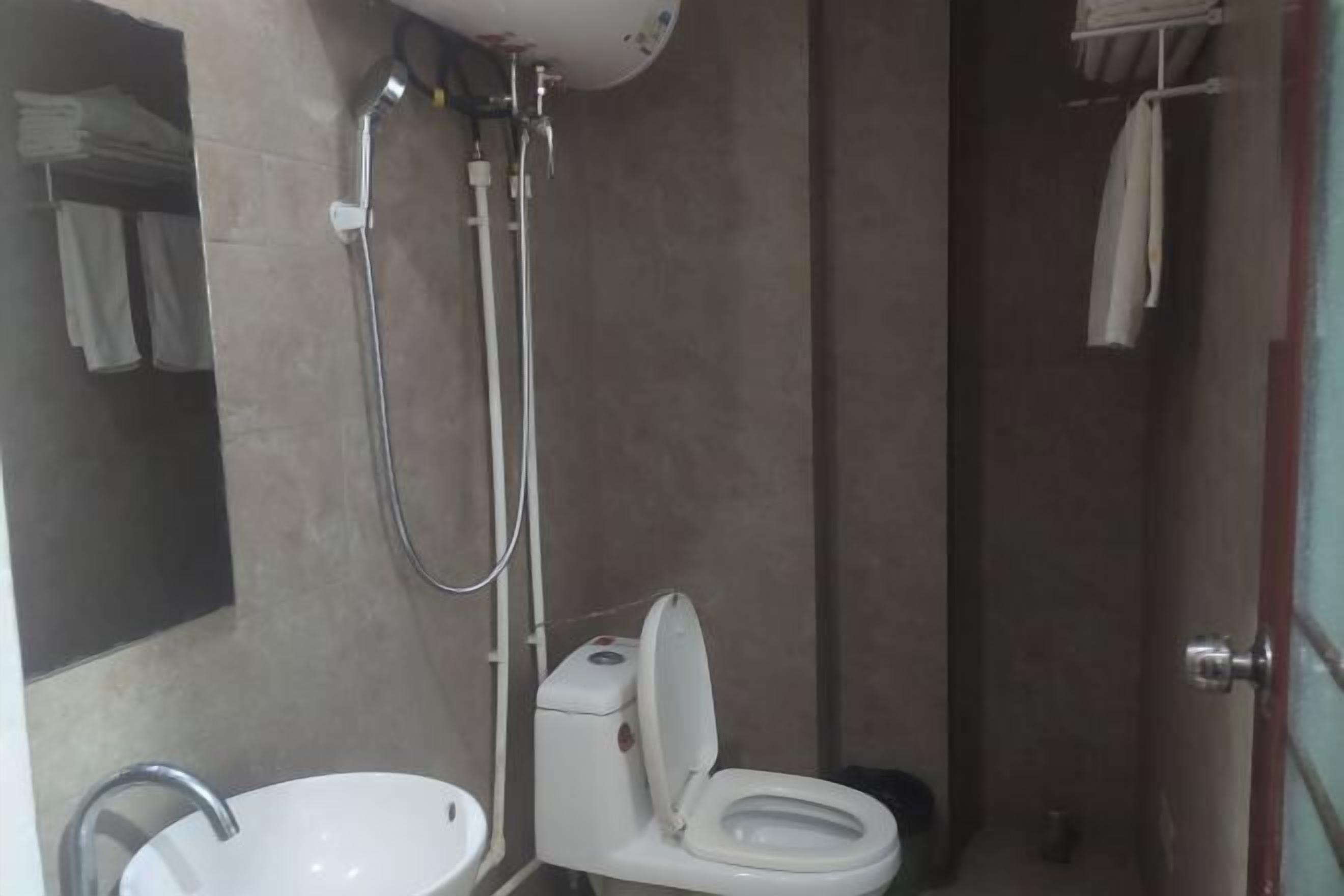 A bathroom with a toilet, sink, and shower.