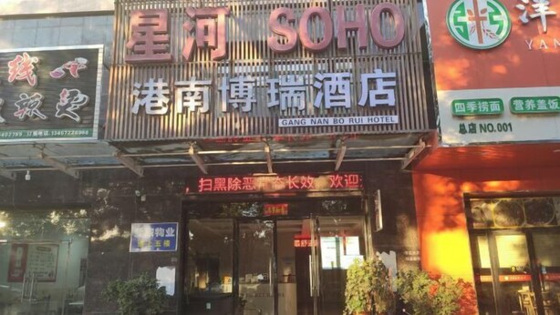 Fachada del hotel Gang Nan Bo Rui, con un letrero llamativo que muestra su nombre y una entrada acogedora.