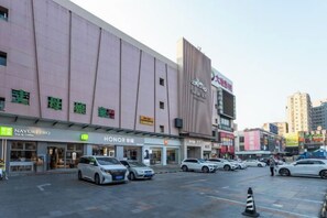 A multi-story building with various commercial establishments on the ground floor, including a car dealership and a clothing store. - Weiyesi Hotel (Shenzhen)