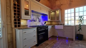 A kitchen with white cabinets, a black stove, and a window with a view of the outside.