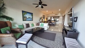 A spacious living room with a sofa set, a coffee table, and a television.