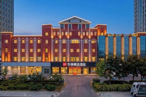Un hotel con una entrada destacada, varios pisos y una fachada bien iluminada.