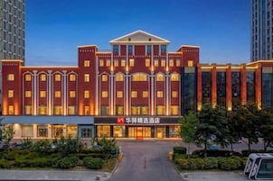 Un hotel de varios pisos con fachada simétrica, ventanas amplias y una entrada central.