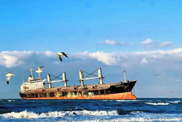 A large cargo ship with multiple cranes and containers, sailing on the ocean. - Home Inn Huaxuan Select Hotel (Weihai High-speed Railway Station Hanlefang Branch) (Weihai)