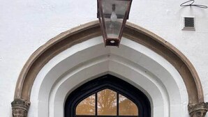 A black door with a white arched entrance and two stone gargoyles. - Inviting 1-bed Apartment in Banbury (Banbury)